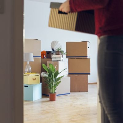 Woman carrying cardboard box in a new home